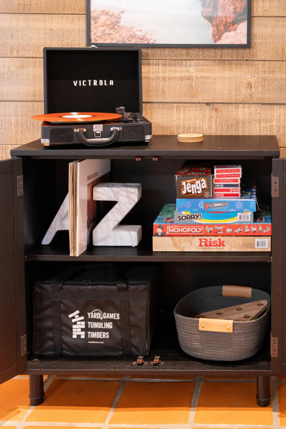 A close-up of board games and a Victrola record player on a stylish console, with decorative 'AZ' letters adding a touch of local flavor. The setup invites playful family moments and relaxing leisure time.